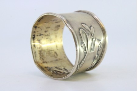 Argola de guardanapo em prata com relevos envolvendo cartela para monograma.